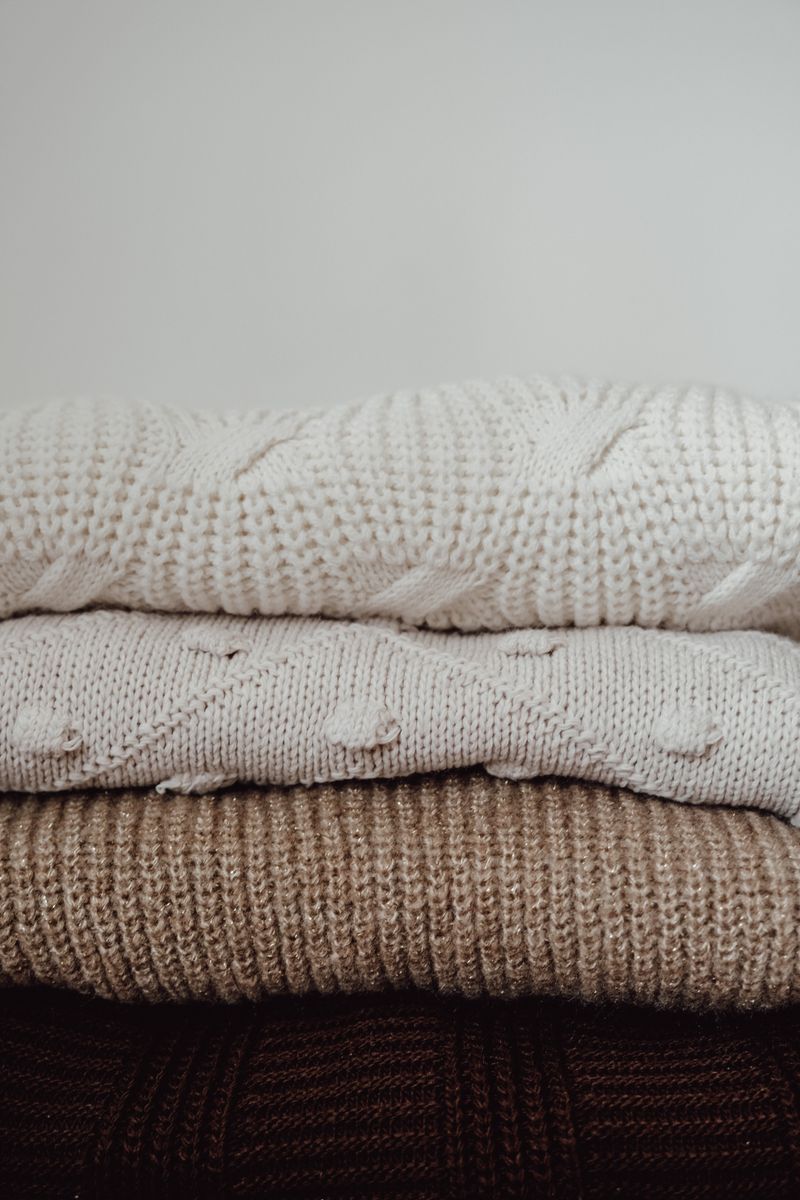 Pile de pulls en maille aux tons neutres