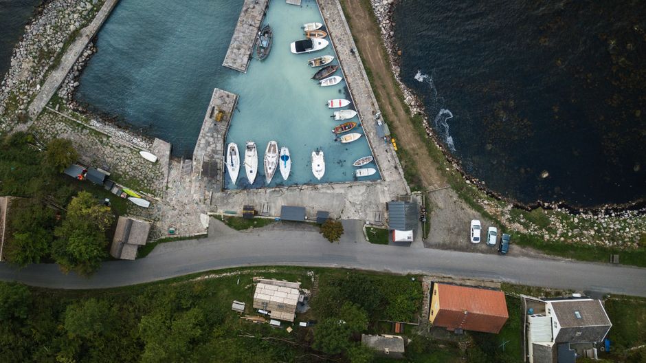 A stunning aerial view of boats docked at Rønne Harbor in Denmark, showcasing the coastal landscape.