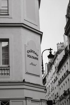 Black and white photo of Château Voltaire Hotel exterior in Paris, showcasing classic architecture.
