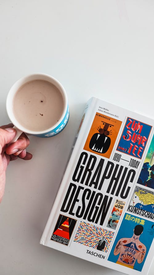 Holding a Cup of Coffee near a Book