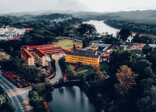 Free Stunning aerial view of Kuala Krai, Kelantan showcasing lush greenery and a winding river. Stock Photo