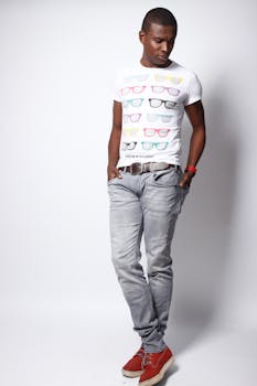 Fashionable male model poses in casual wear with graphic tee and jeans in studio setting.
