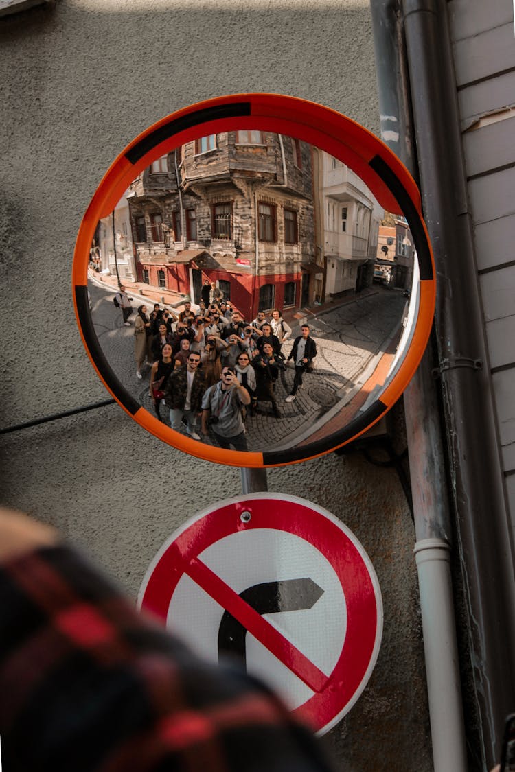 People Taking Photo In Traffic Mirror