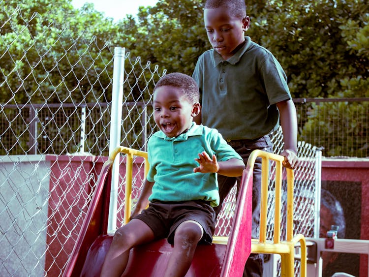 Boys Playing On A Slide Together