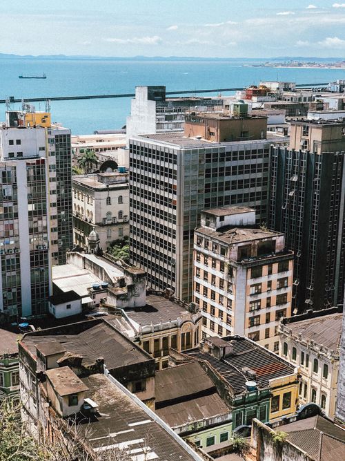 Free Elevated urban cityscape with diverse buildings and ocean horizon in the background. Stock Photo