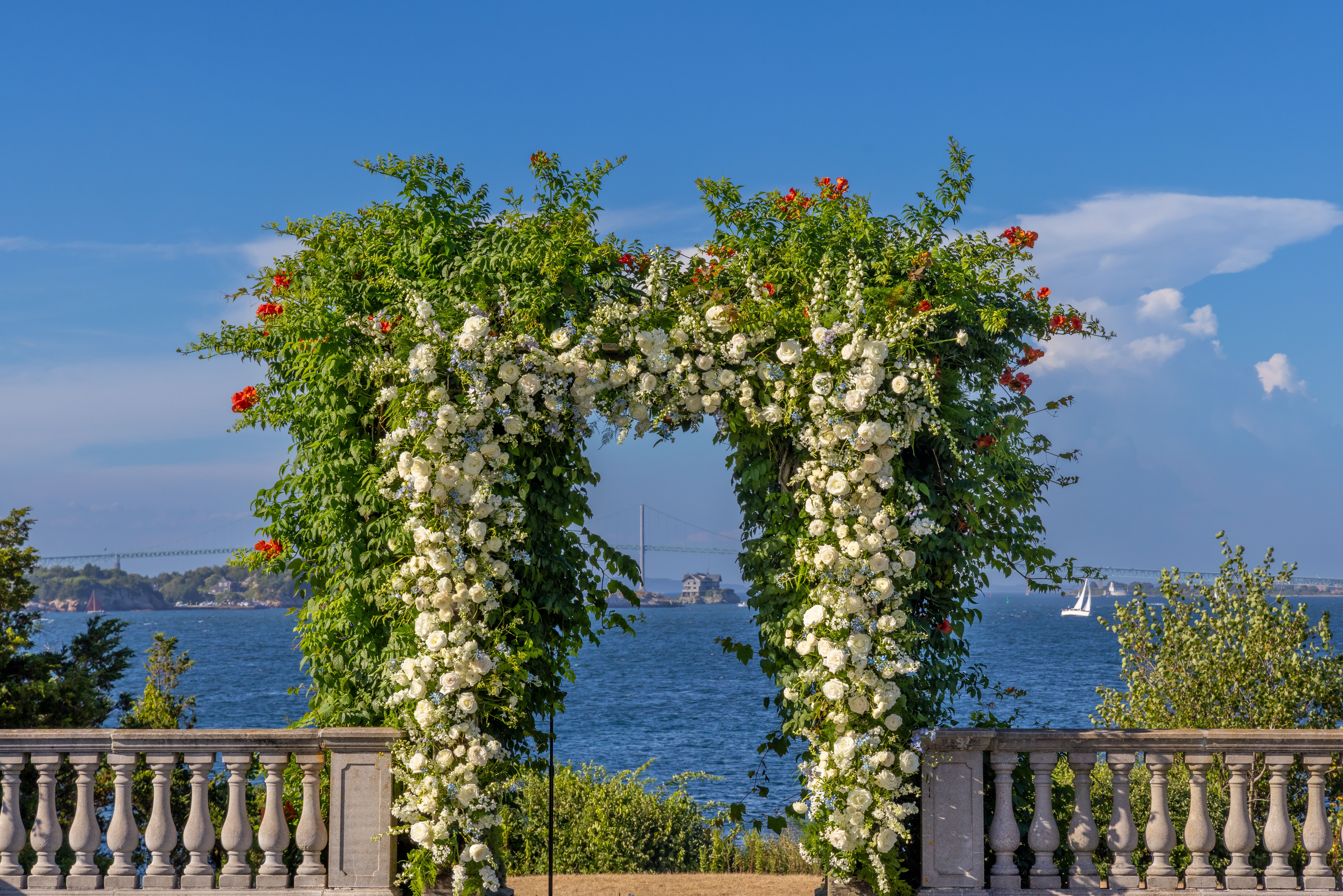 A sweeping floral arch framing a wedding ceremony space