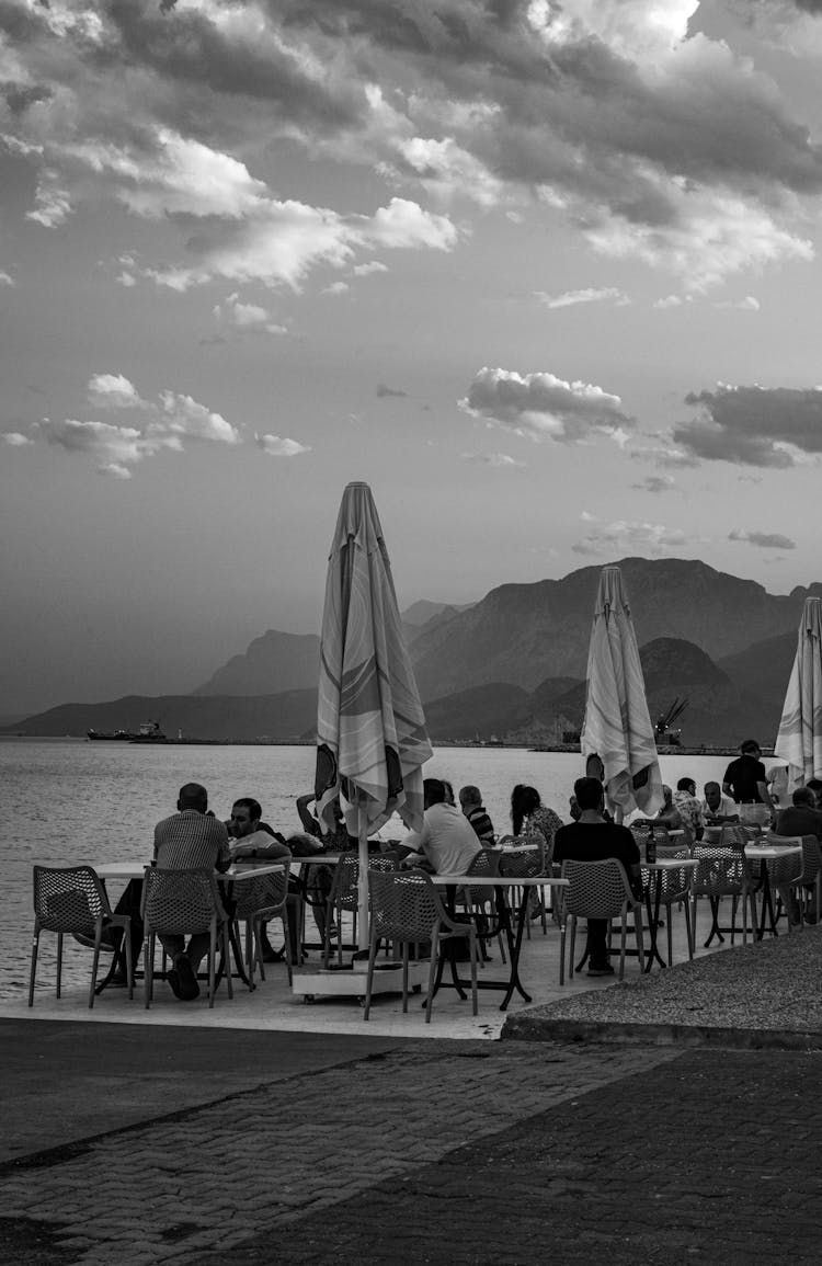 People Sitting On Restaurant Terrace Near Water