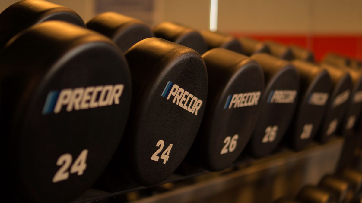 Close-up of Precor dumbbells neatly arranged in a gym for fitness enthusiasts.