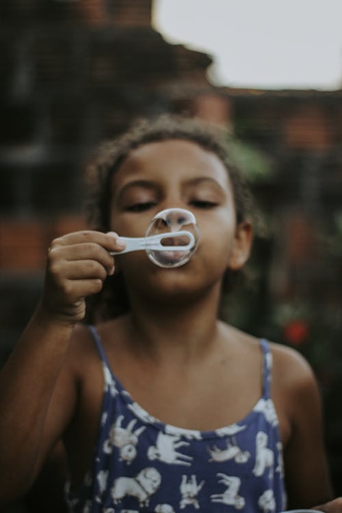 Close Up Photo of Girl Blowing Bubble