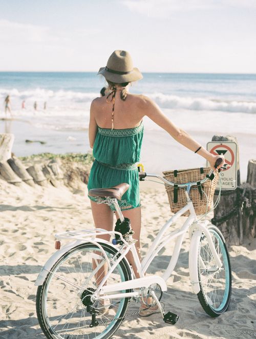 Free Woman in sundress with bicycle on Newport Beach enjoying a sunny day. Stock Photo