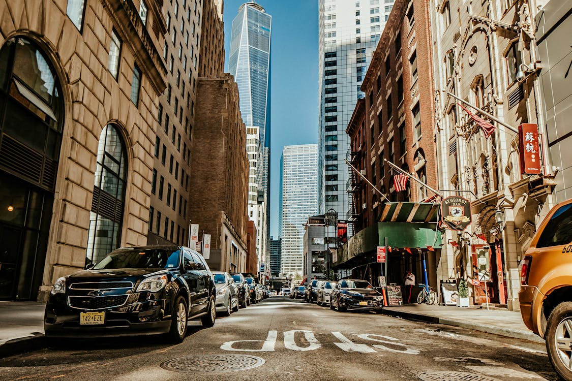 Vehicles on Road Between Buildings