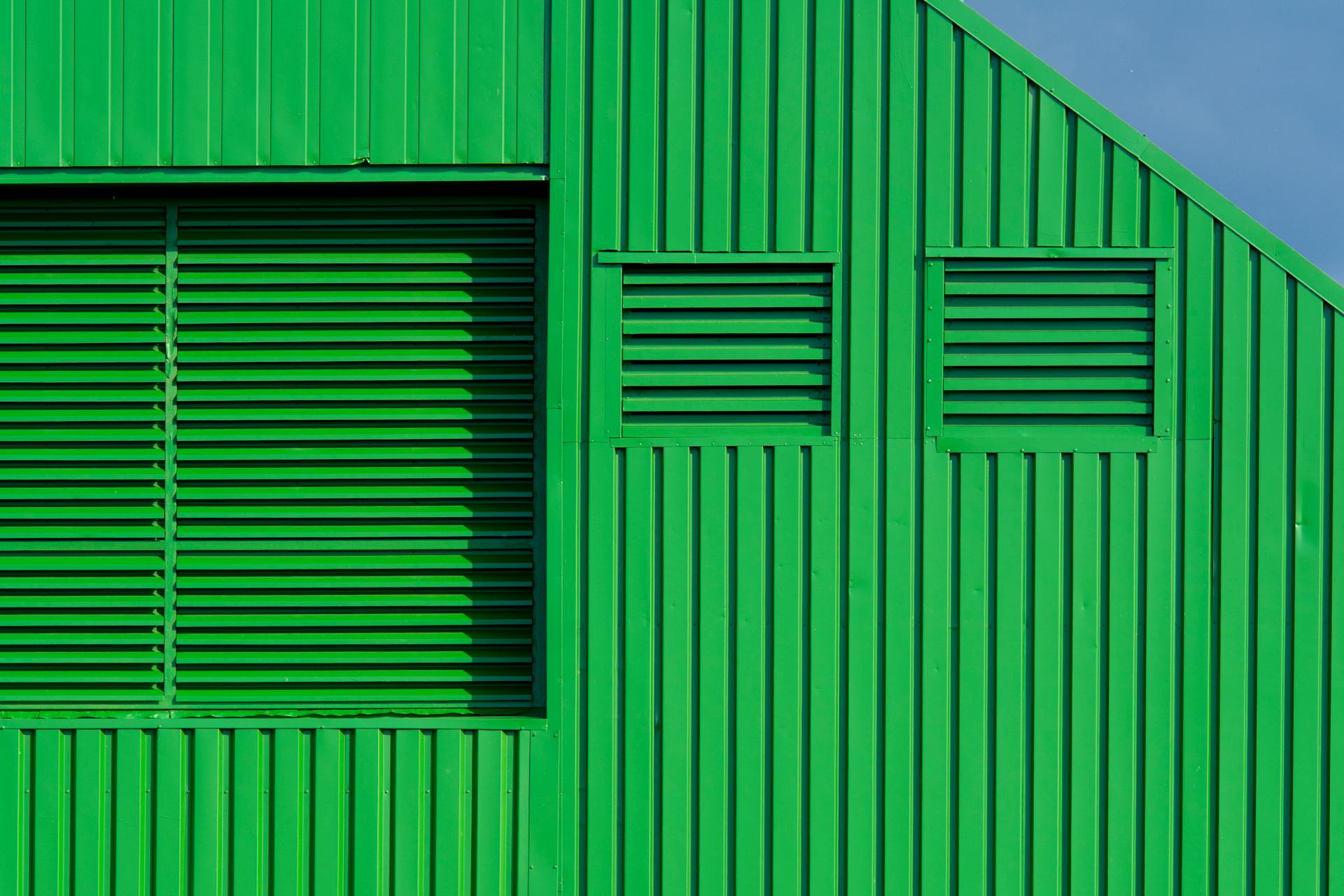 Bright green wall with geometric louvered pattern, ideal for modern architectural themes.