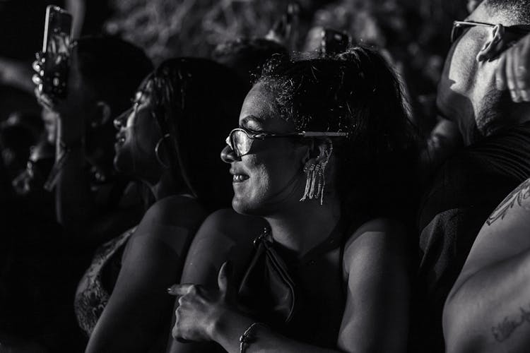 Grayscale Photo Of A Smiling Woman At A Concert