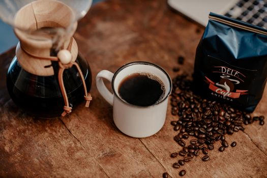 A cozy setup of coffee beans, cup, and Chemex on a wooden table in Antigua Guatemala.