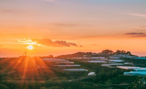 Free Beautiful sunset over a lush countryside with sprawling fields and distant mountains. Stock Photo