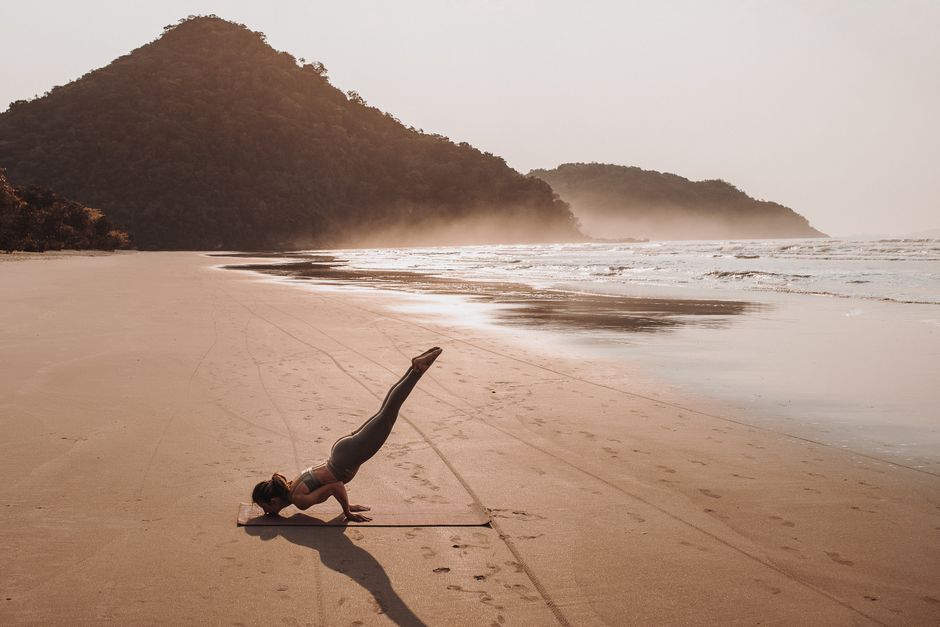 Wellness retreat participants enjoying yoga on a beach at sunset - SEO for wellness retreats