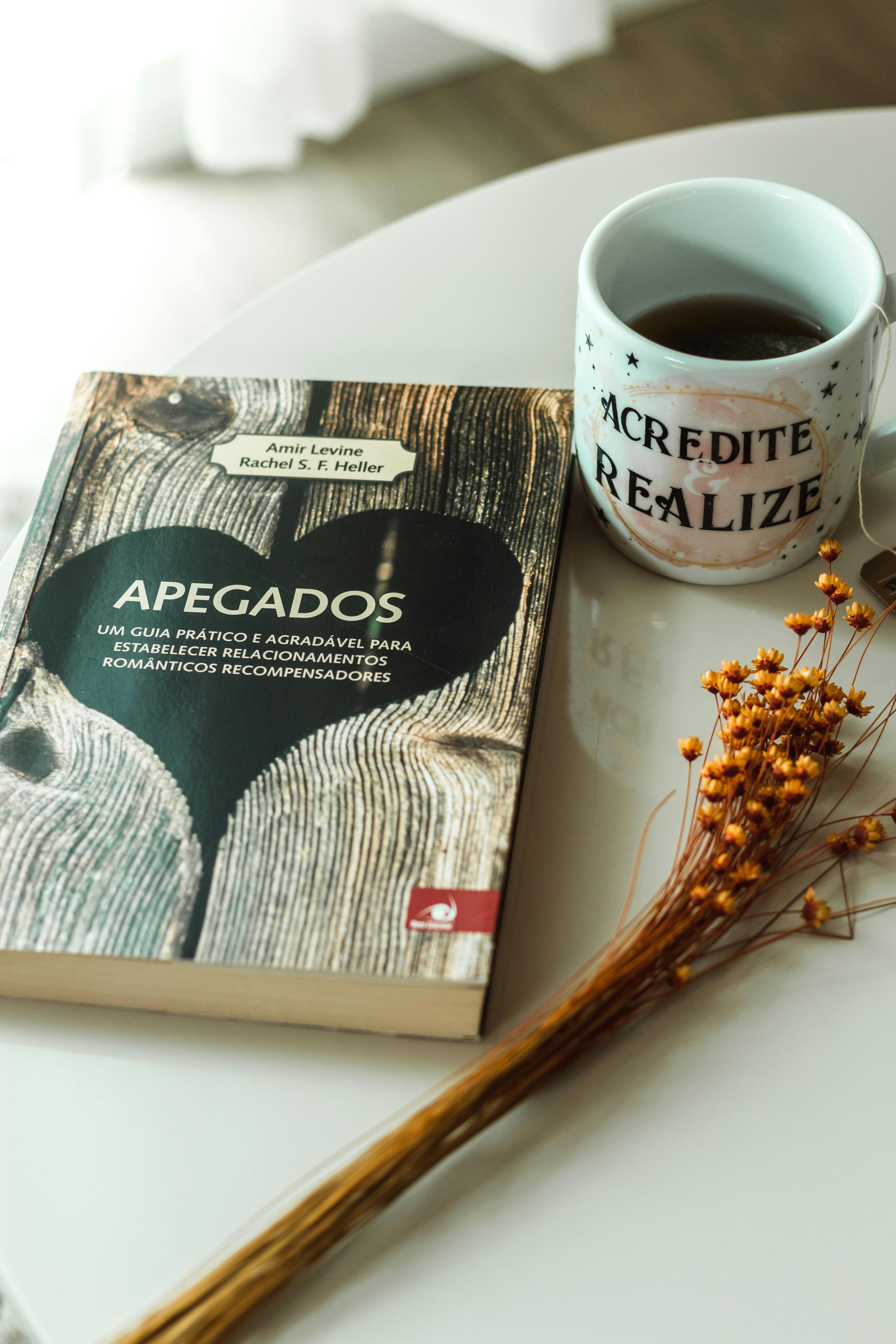Livro aberto ao lado de uma chávena de café
