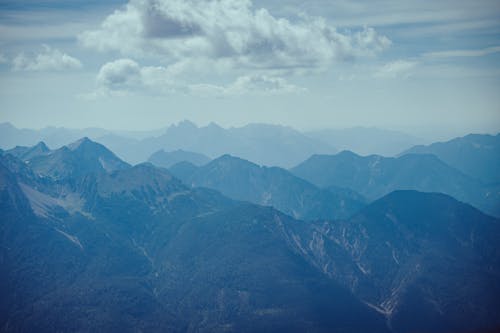Free Breathtaking aerial view showcasing a misty mountain range beneath a cloudy sky. Stock Photo