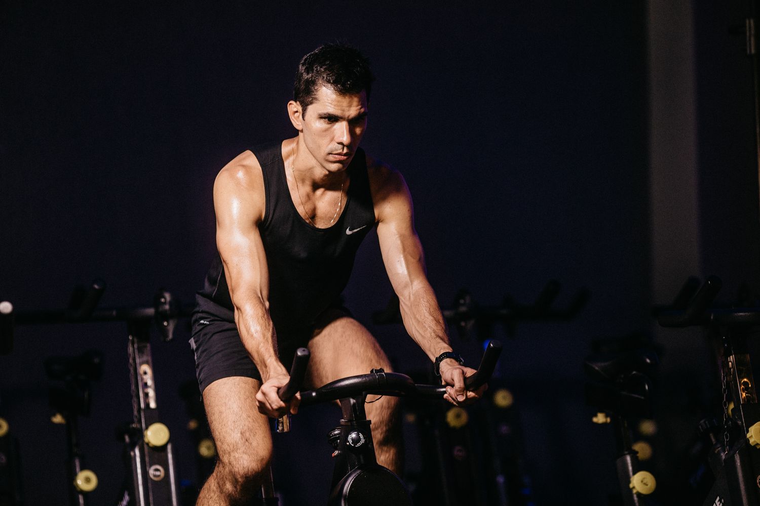 Rows of neon-lit spin bikes