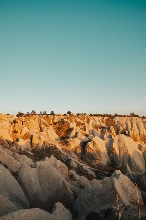 Free Explore the eroded rock formations in this bright landscape captured at golden hour with a clear sky. Stock Photo