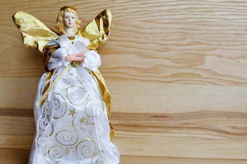 Free Angel Ceramic Figurine on Beige Wooden Surface Stock Photo
