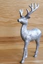 这款银色驯鹿雕塑在木制表面闪闪发光，非常适合装饰