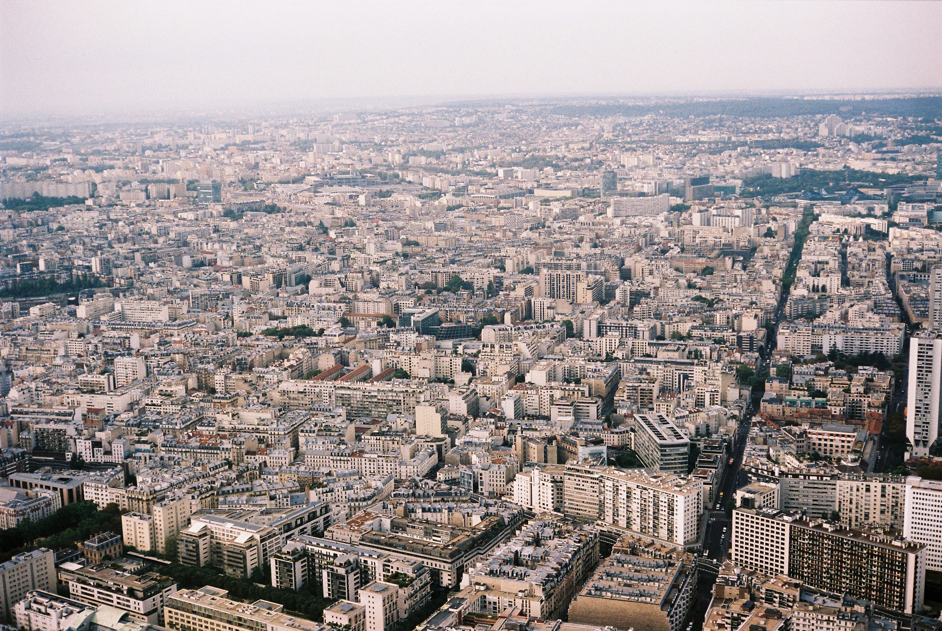 Expansive aerial view of Paris displaying dense urban architecture and skyline from above.