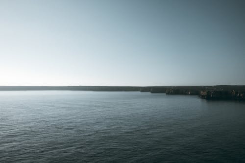 Land Along a Body of Water Under a Blue Sky