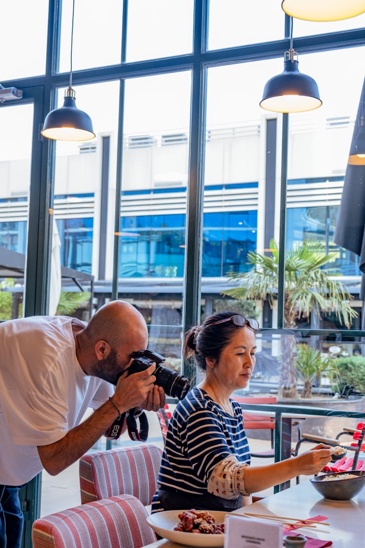 Man Photographing Food At Restaurant