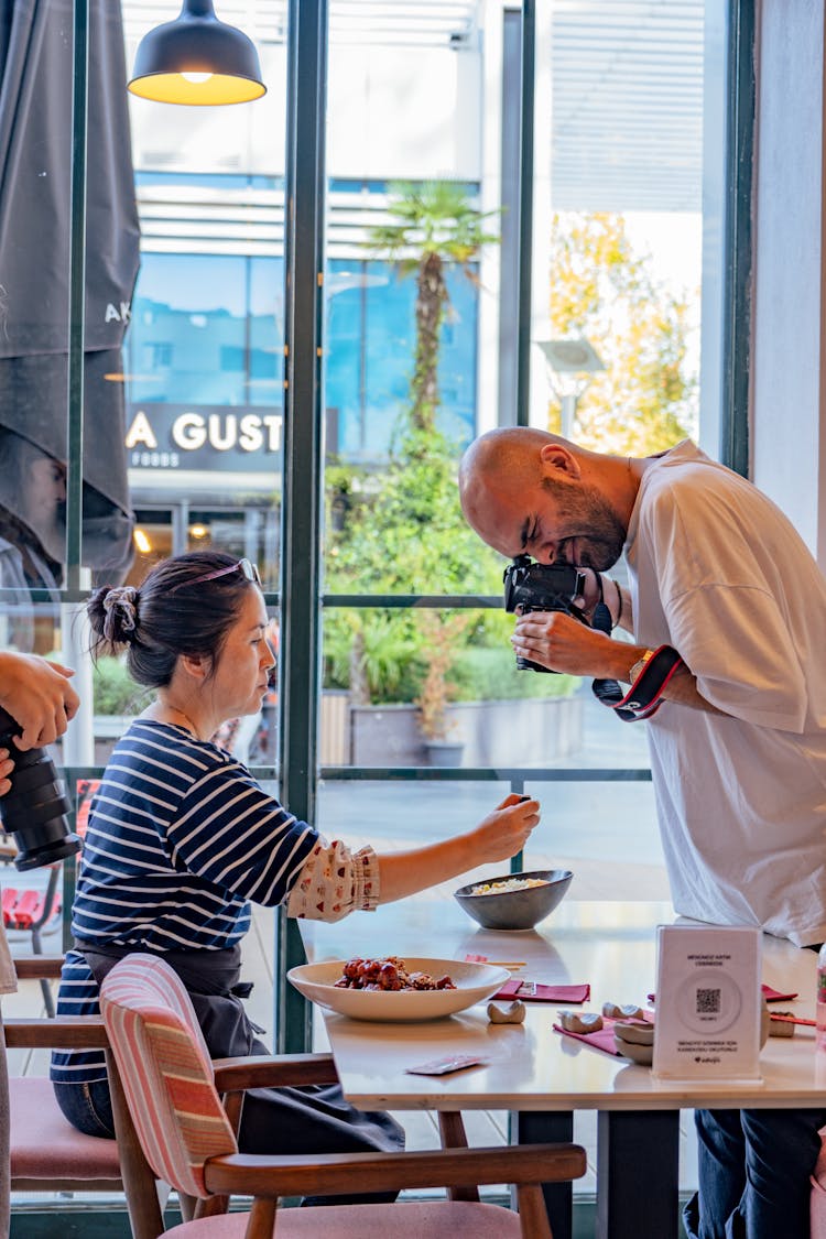 Man Photographing Food In A Restaurant 