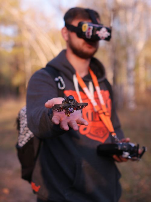 Free A man using goggles controls a mini drone outdoors in a scenic autumn forest. Stock Photo