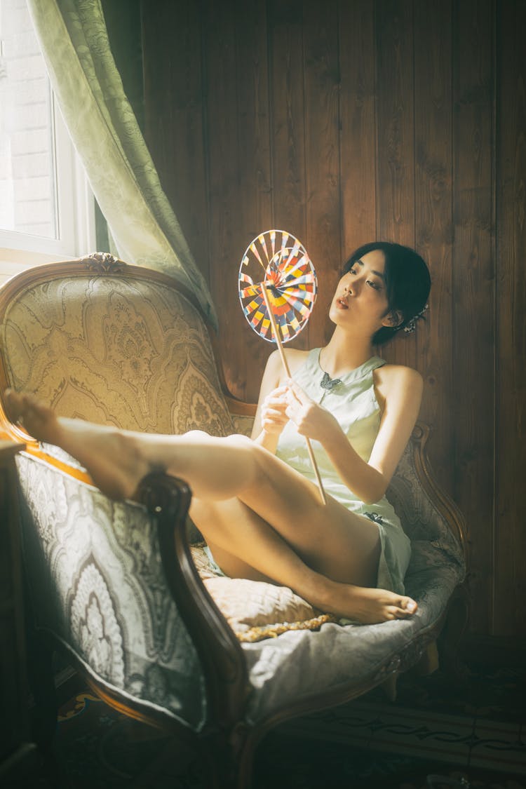 Asian Woman Sitting In Armchair