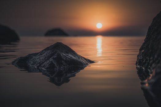 Beautiful sunset over a calm ocean with rocks in Ordu, Türkiye.