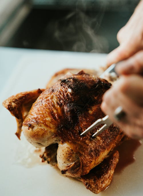 Hands Cutting Steamy Chicken