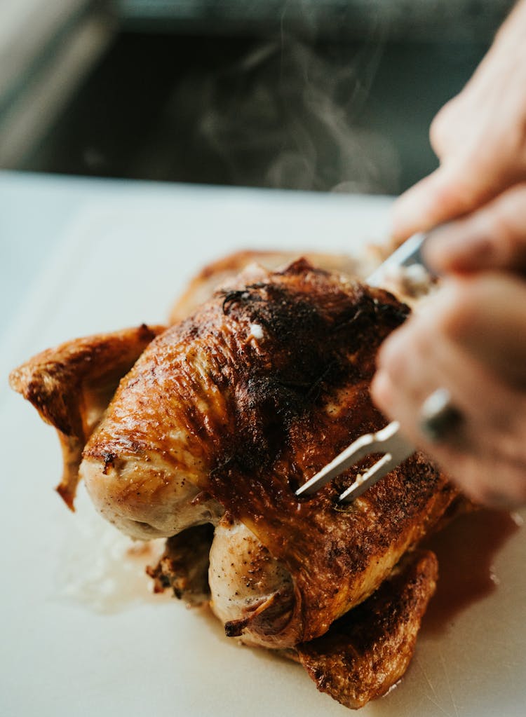 Hands Cutting Steamy Chicken