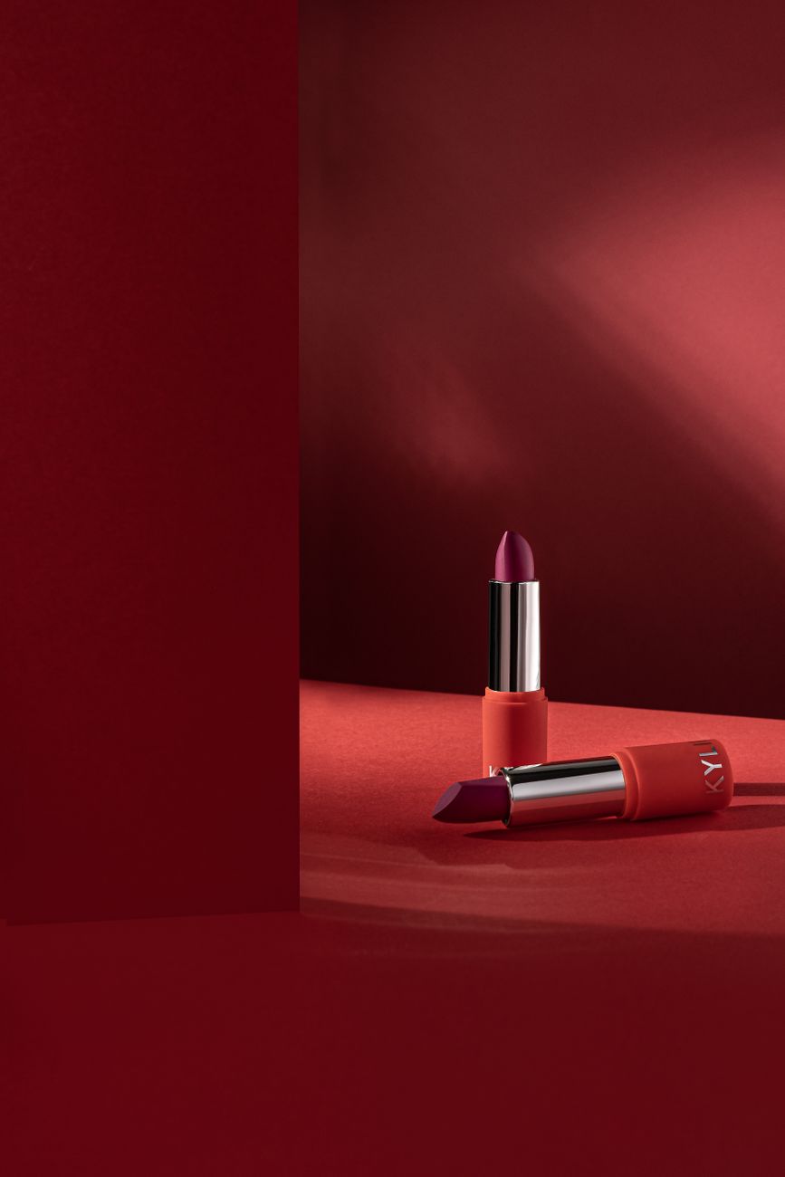 Elegant lipstick display in a studio with rich red tones, highlighting glamour and luxury.