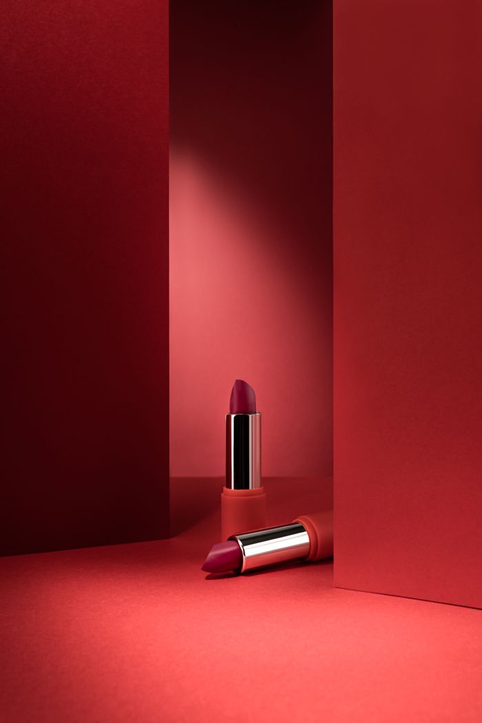 Lipstick standing on a plinth against a deep red background
