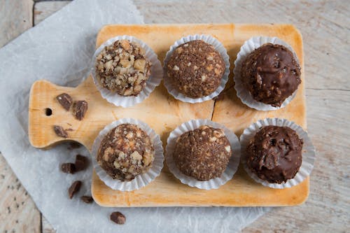 Free Top View of Chocolate Balls with Different Toppings on a Cutting Board  Stock Photo