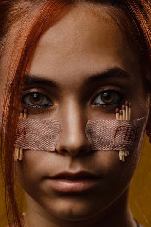 Woman with Matchsticks Taped to Her Face with Band-Aids