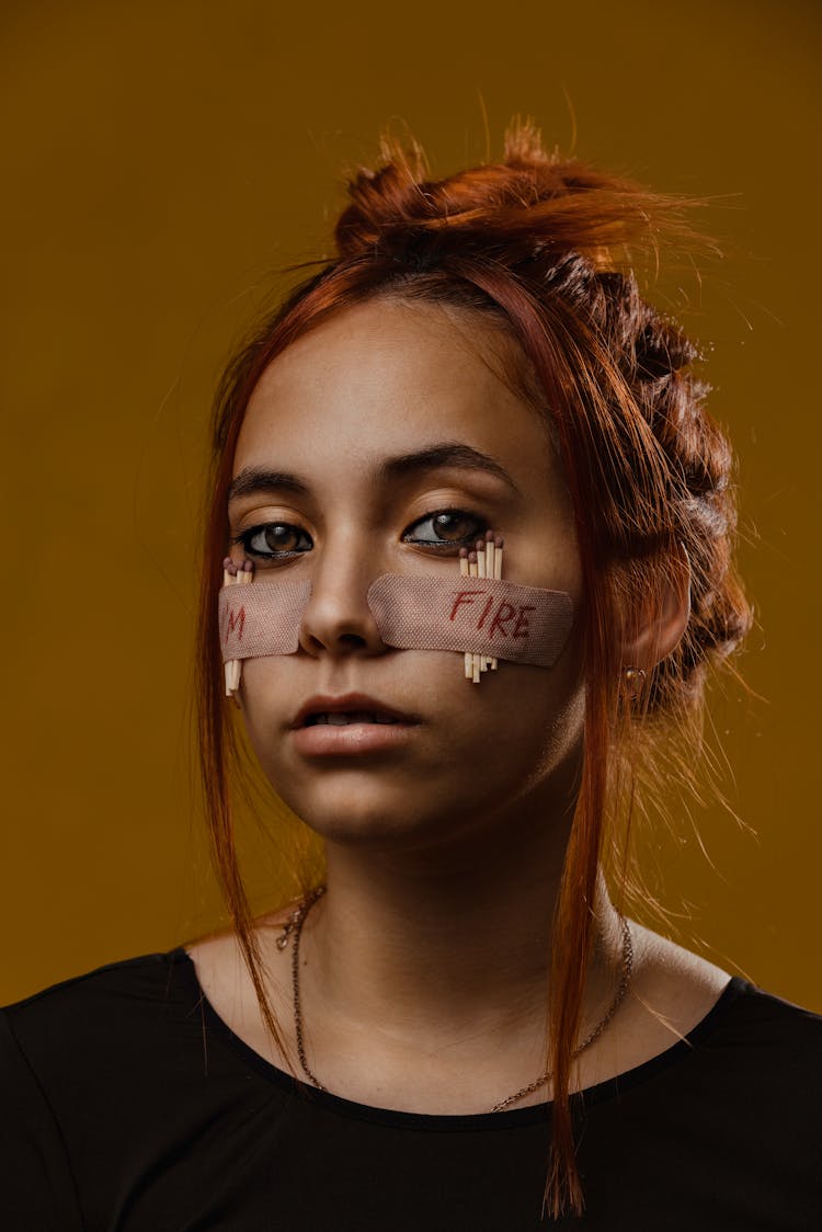 Portrait Of A Woman With Matchsticks Taped To Her Face With Band-aids