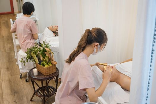 Two professionals provide soothing massage therapy in a calming spa environment.