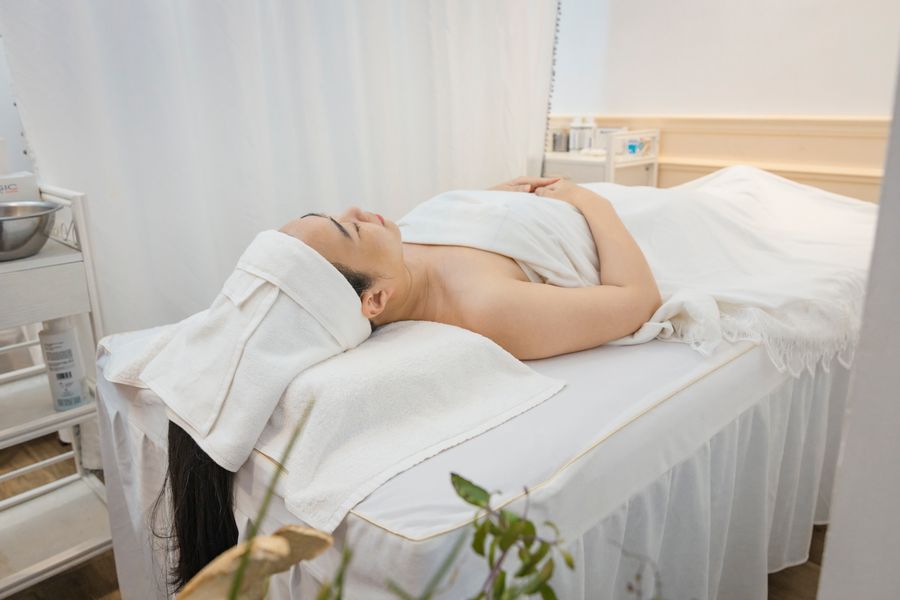 Woman resting peacefully on a treatment bed in a clean wellness setting after a session