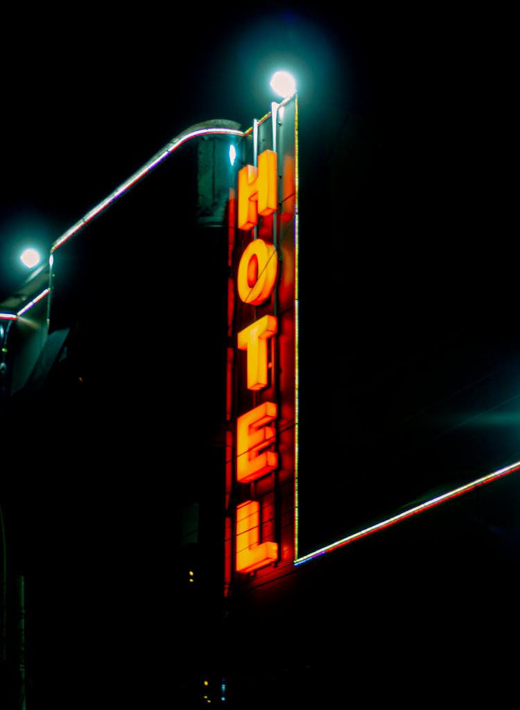 Lighted Hotel Signage Beside A Building During Night Time