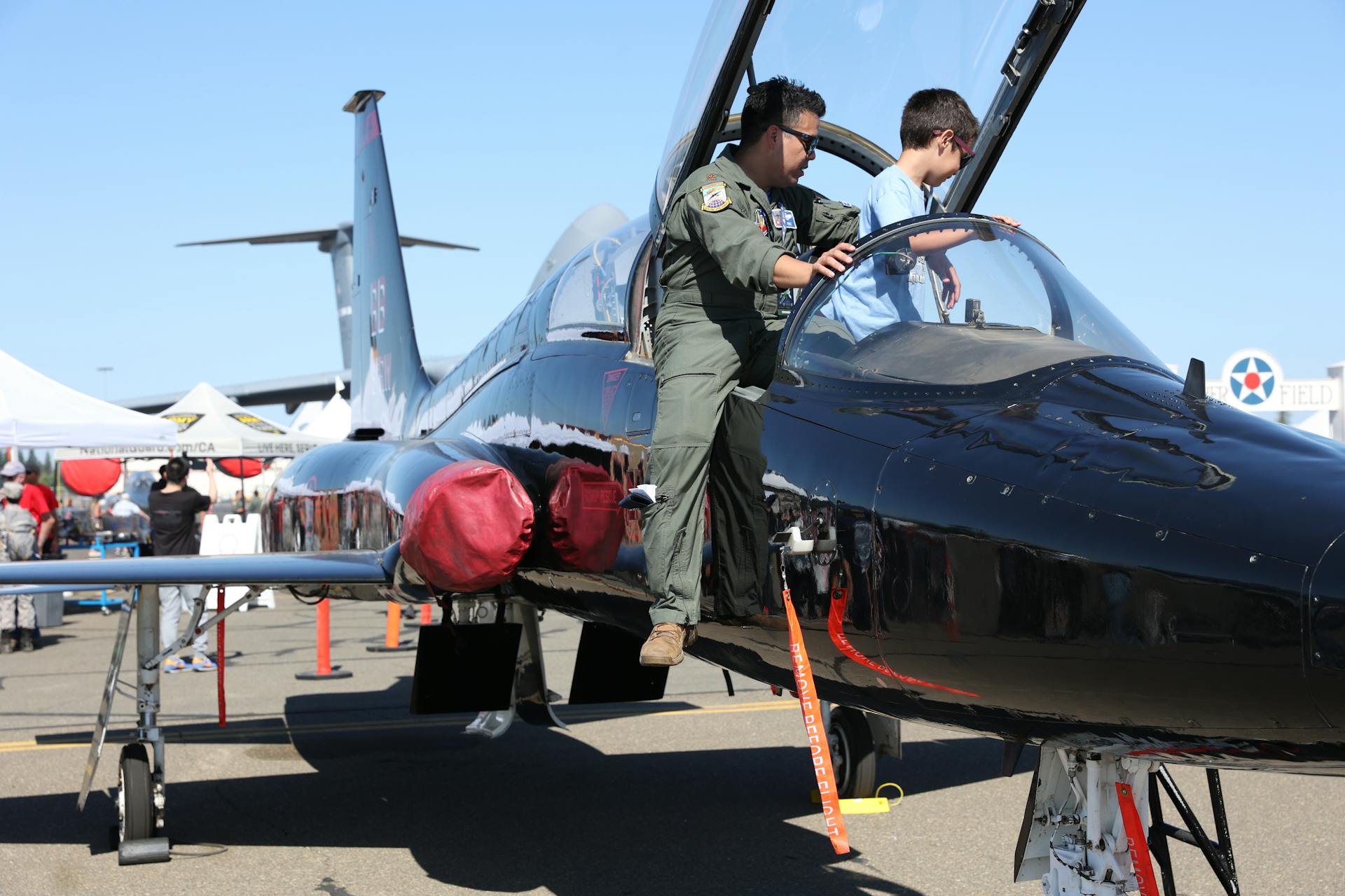 2 Men in Black and Red Suit Riding on Black Jet Plane