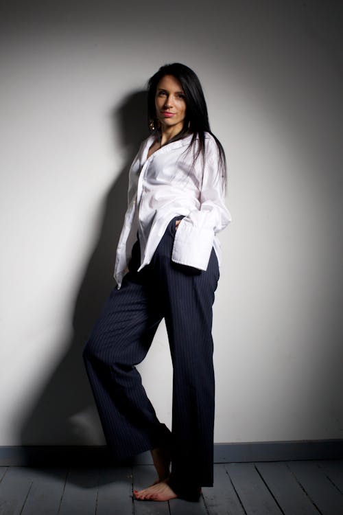 Young Fashionable Woman Wearing a White Shirt and Navy Suit Pants 