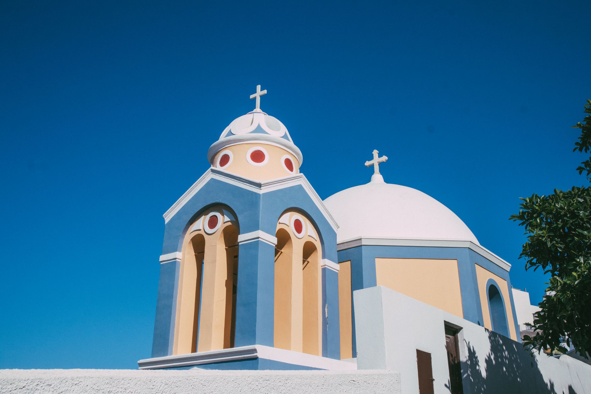 Stunning blue domed church in Santorini under a bright blue sky, showcasing Greek architecture.