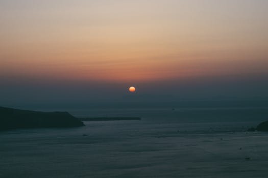 A tranquil ocean scene during sunset with vibrant sky hues and calm waters, perfect for relaxation themes.