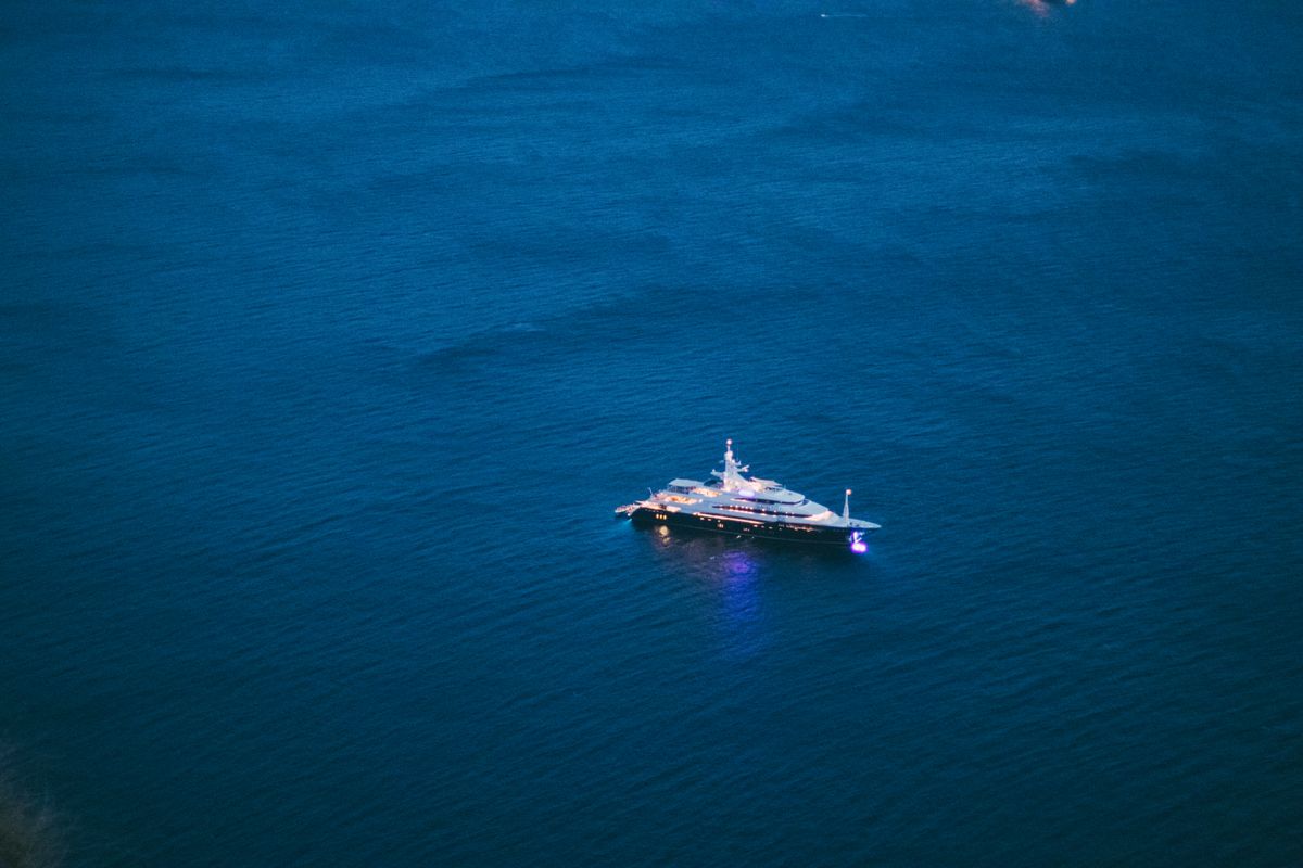 Yacht glowing on calm water after dark