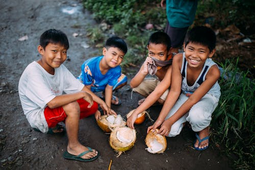 Empat Anak Laki Laki Memegang Batok Kelapa