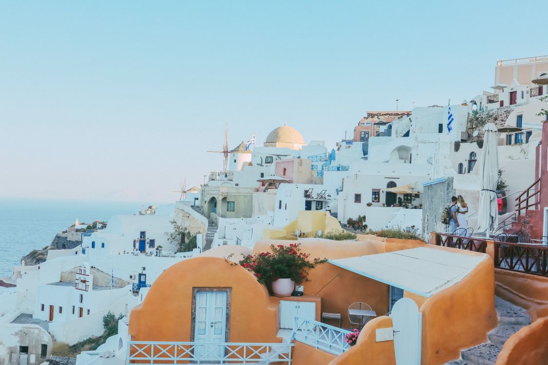 Free Explore the iconic whitewashed buildings of Oia, Santorini, under a clear blue sky, capturing Greek island charm. Stock Photo